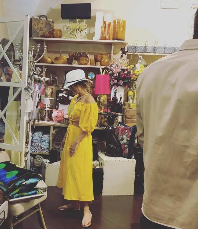 Lopez uso un vestido amarillo casual mientras miraba la mercancia de la tienda