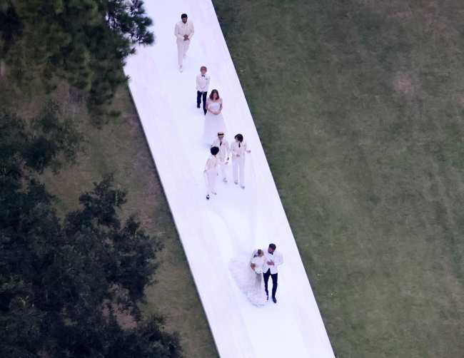 Los cinco hijos colectivos de la pareja ayudaron a llevar el velo de la novia al salir de la ceremonia