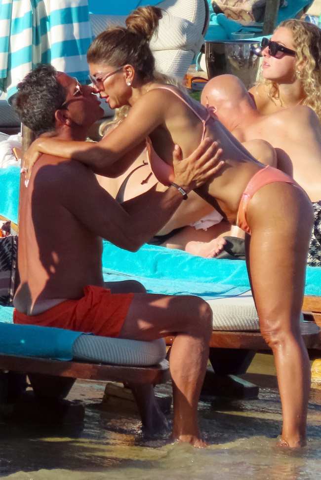 Teresa Giudice se puso un bikini de color coral mientras se subia encima de su nuevo esposo Luis Ruelas para una sesion de besos