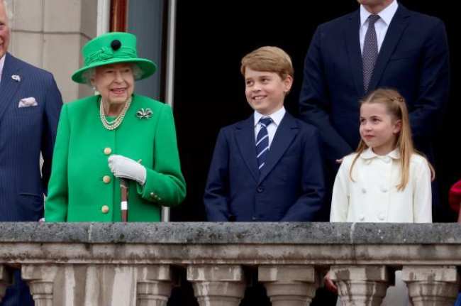 La reina Isabel II el principe Jorge de Cambridge y la princesa Carlota de Cambridge de pie