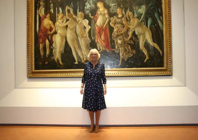 La futura reina consorte Camilla poso con la pintura que inspiro el vestido de la princesa Isabel durante una visita real a Florencia Italia en 2017