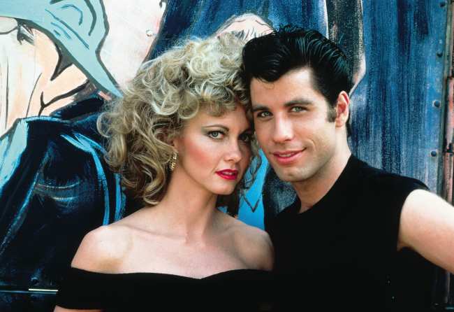 Rinder escribe que fue designado para ayudar a Travolta arriba con Olivia Newton John en Grease a combatir los rumores de homosexualidad
