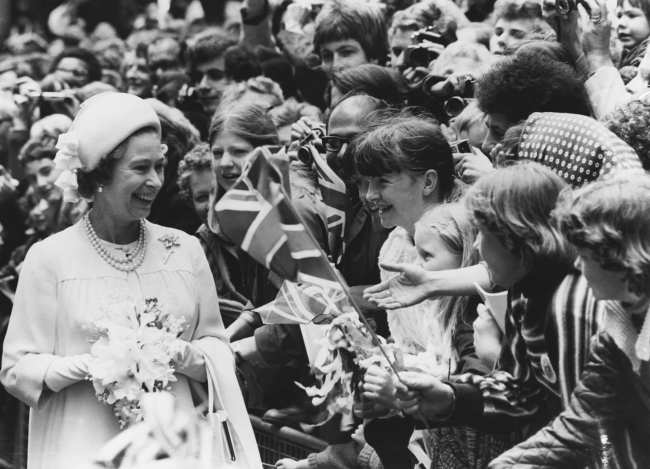 La reina Isabel II lucio sus aretes de perlas mientras saludaba a la multitud durante su Jubileo de Plata en 1977