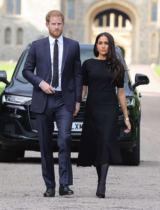 El principe Harry y Meghan Markle caminan juntos frente al castillo de Windsor