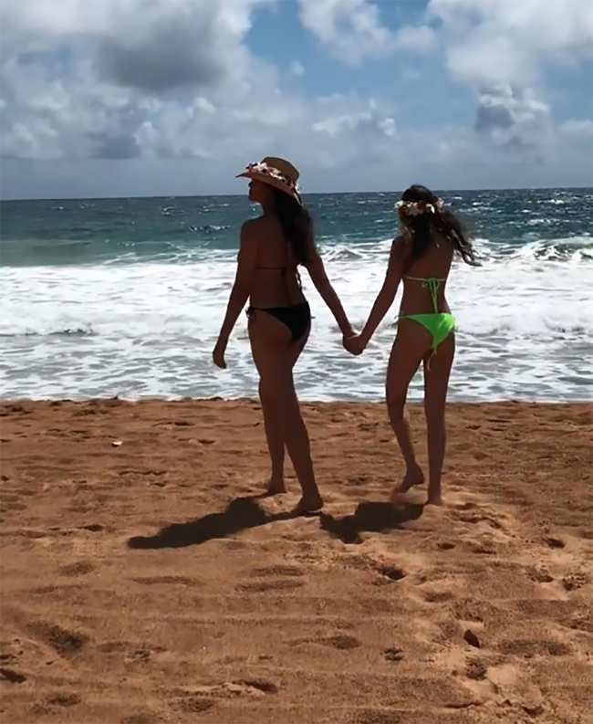 Lakshmi tomo de la mano a su hija en la playa a principios de este ano