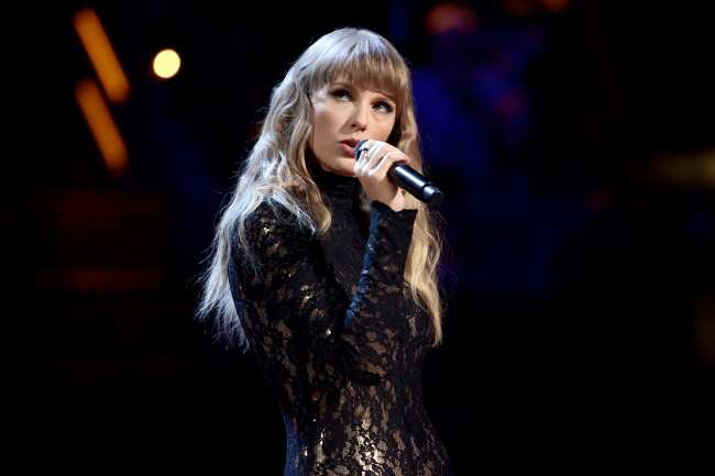 Taylor Swift actuando con un top de encaje negro