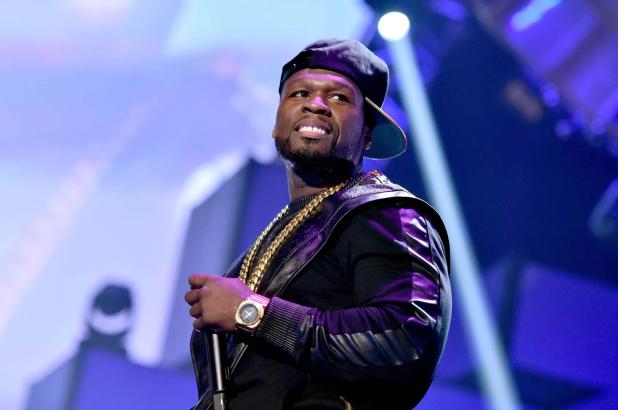 50 Cent sosteniendo un microfono en un escenario