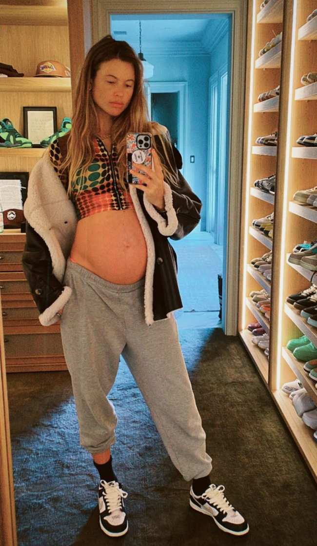 Behati Prinsloo embarazada muestra su panza en un top corto mientras se toma una selfie en el espejo de un armario