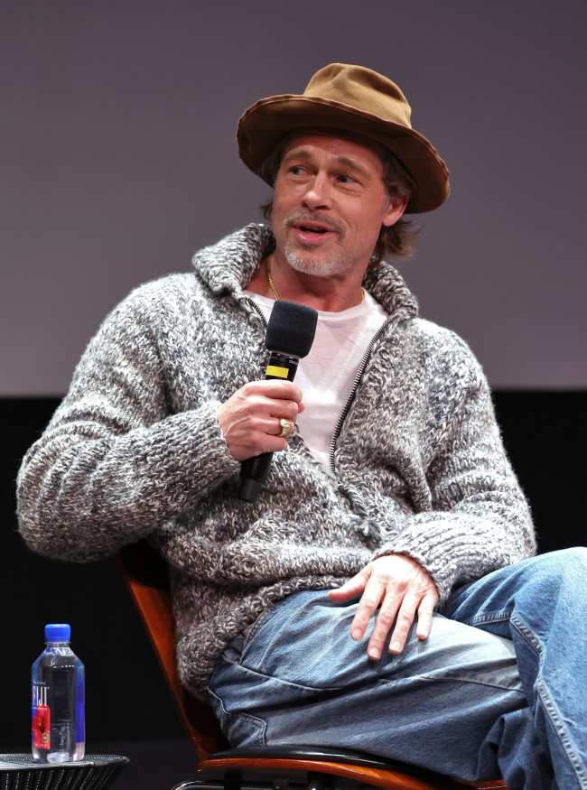              Pitt mantuvo las cosas informales para el concierto con una sudadera jeans y un sombrero marron            