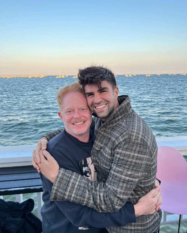 Jesse Tyler Ferguson y Justin Mikita abrazados en un bote