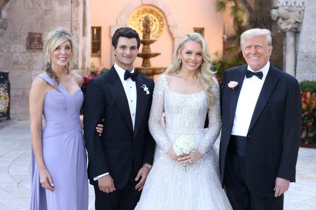              Tiffany fotografiada aqui con su nuevo esposo su mama Marla Maples y su papa eligio un vestido de Elie Saab con mangas largas y cuentas intrincadas             