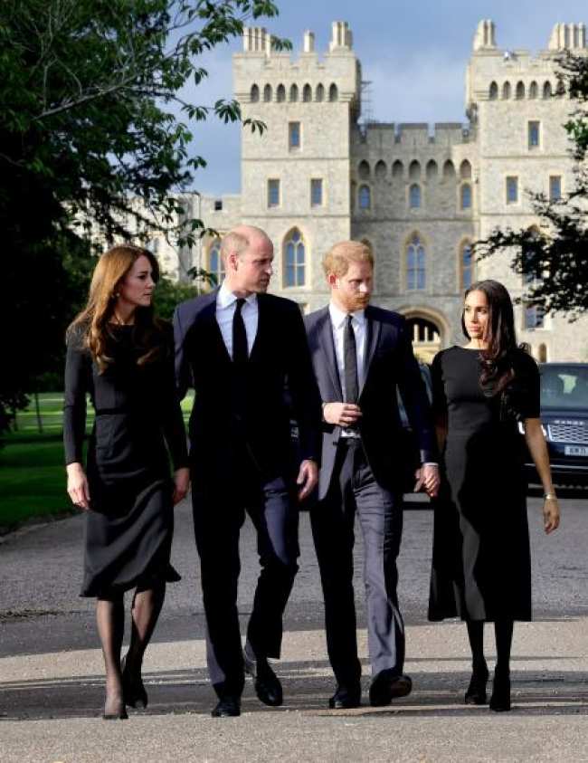 El principe William Kate Middleton Meghan Markle y el principe Harry caminando juntos frente a un castillo