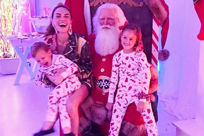 Elizabeth Chambers y sus dos hijos posando para una foto con Santa