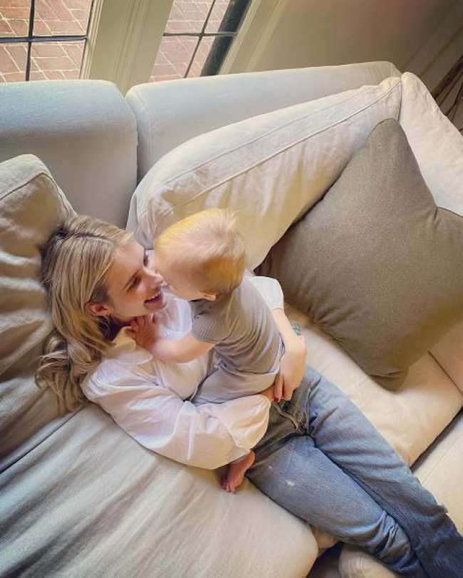 Emma Roberts y su hijo Rhodes acurrucados en un sofa