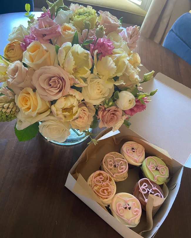              El esposo y la esposa celebraron la revelacion publica con pastelitos y flores            