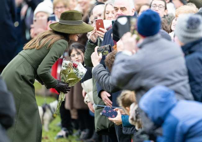 Kate Middleton aceptando flores de un fan real