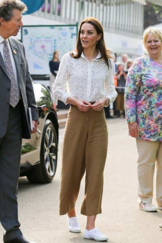 Kate Middleton con zapatillas Superga y blusa blanca con pantalones color canela