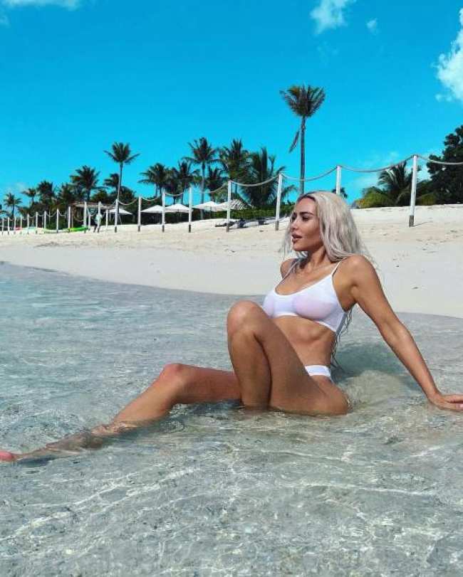Kim Kardashian sentada en una playa