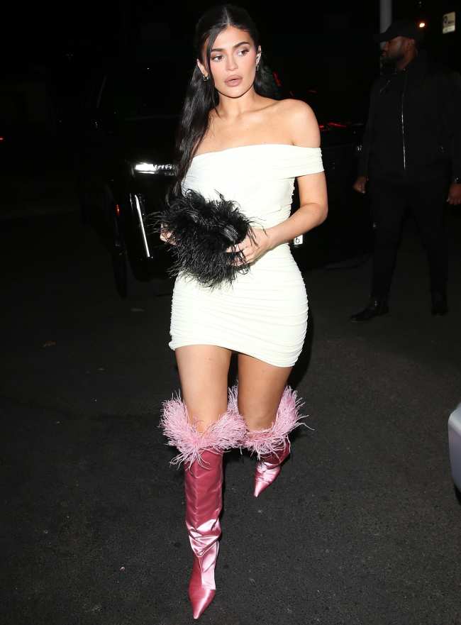              Jenner celebro en una fiesta navidena con sus empleados y su familia con un vestido blanco ajustado al cuerpo con botas de plumas hasta la rodilla ambos de Alexander Wang            