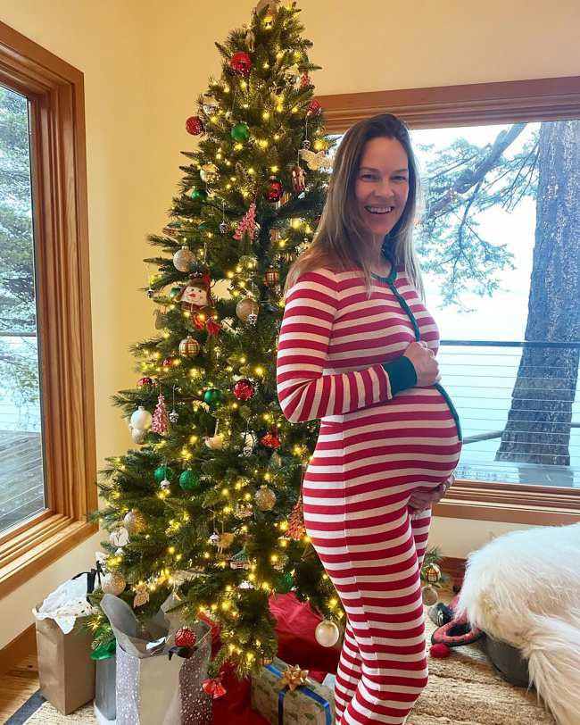Hilary Swank embarazada posando frente a un arbol de Navidad
