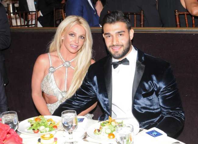 Sam Asghari y Britney Spears sentados a la mesa