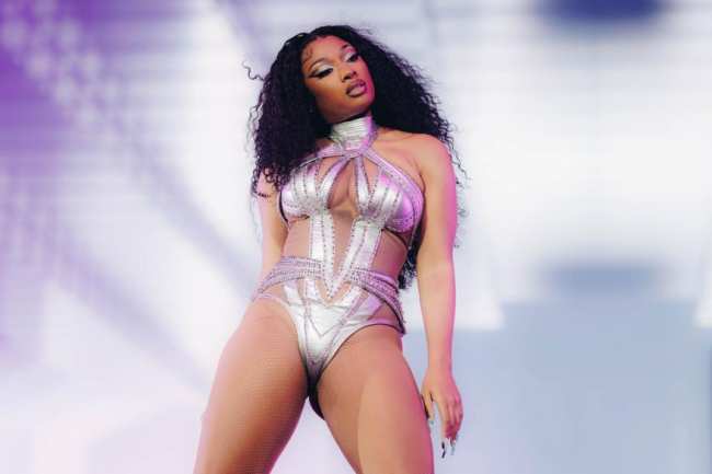 Megan Thee Stallion actuando en el escenario con un sexy traje plateado