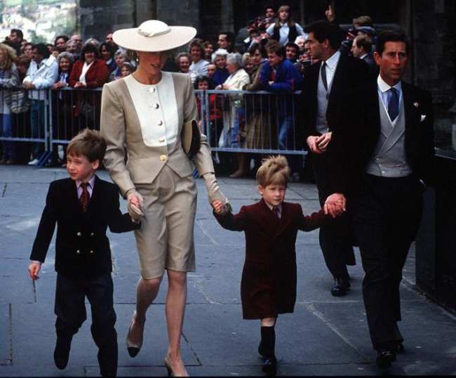 La princesa Diana y el rey Carlos caminando con un joven principe Harry y el principe William