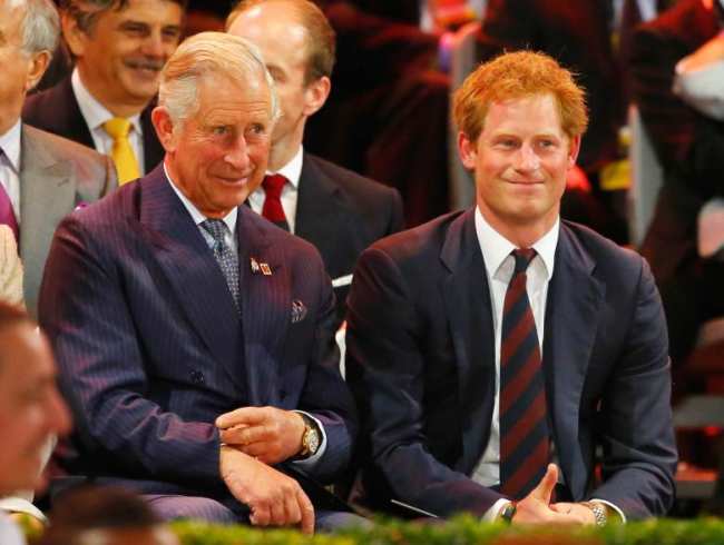 El rey Carlos III y el principe Harry sentados uno al lado del otro en un evento