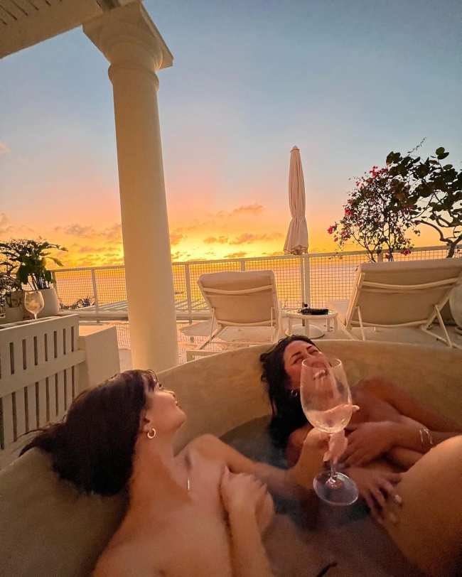              La modelo y un amigo se rieron mientras disfrutaban de un momento en la banera de hidromasaje en topless             