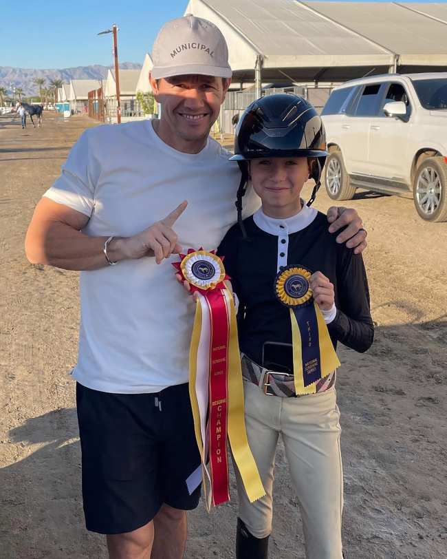 Mark Wahlberg y su hija Grace sosteniendo sus premios de equitacion