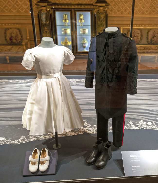             El vestido de dama de honor de la princesa Charlotte junto con el traje de paje del principe George se incluyeron en una exhibicion de bodas reales de 2018            