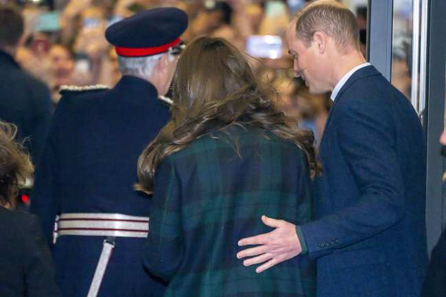              El principe William coloco una mano en la espalda de su esposa mientras se acercaban a un mar de personas en el hospital            