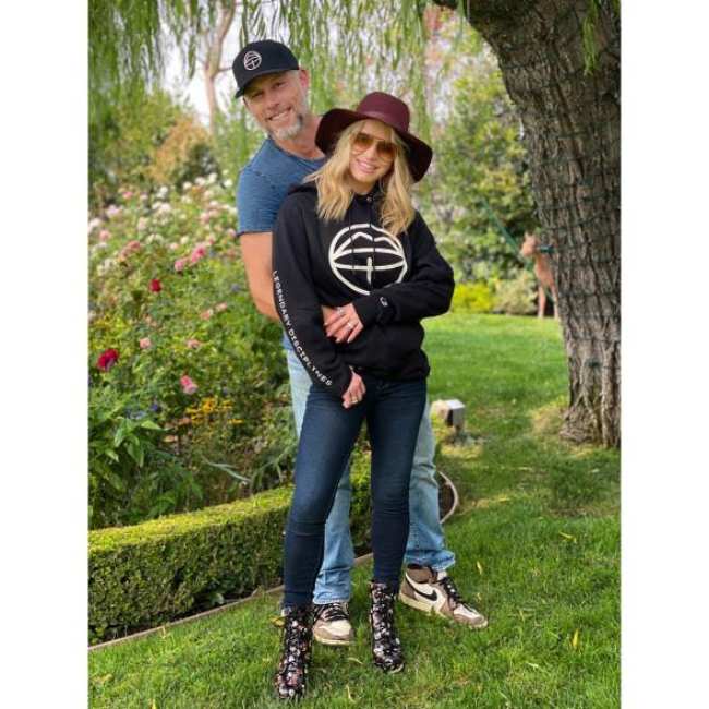 Una foto de Eric Johnson y Jessica Simpson posando juntos para una foto al aire libre