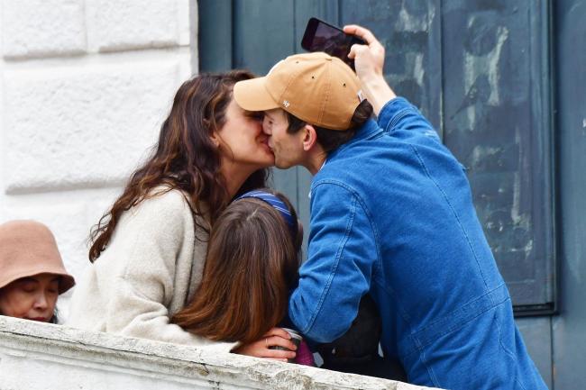 La pareja compartio un dulce beso mientras se tomaban una foto familiar