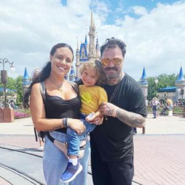 Bam Margera y Nicole Boyd posando con su hijo en Disneyland