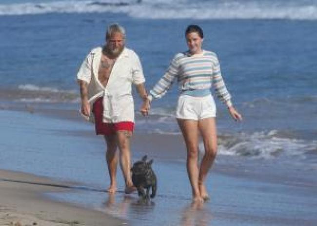 Olivia Millar y Jonah Hill caminan en la playa con un perro