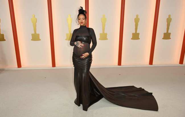 Rihanna acuno su barriga en la alfombra color champan