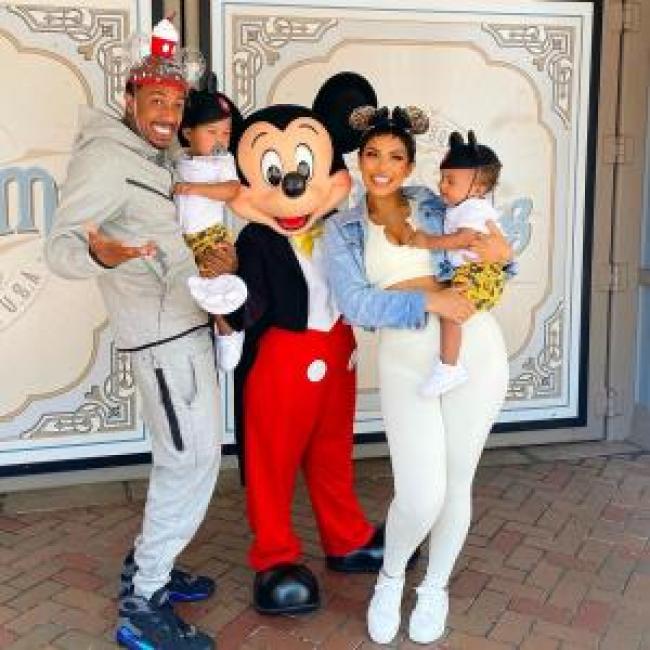Nick Cannon y Abby De La Rosa sostienen a sus hijos Zion y Zillion en Disneyland