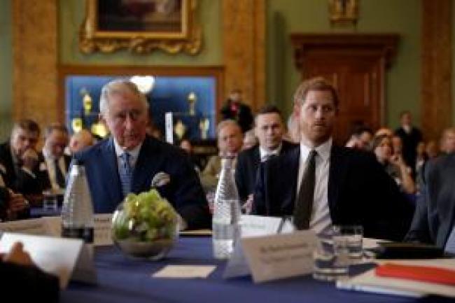 El principe Harry con el rey Carlos en una mesa