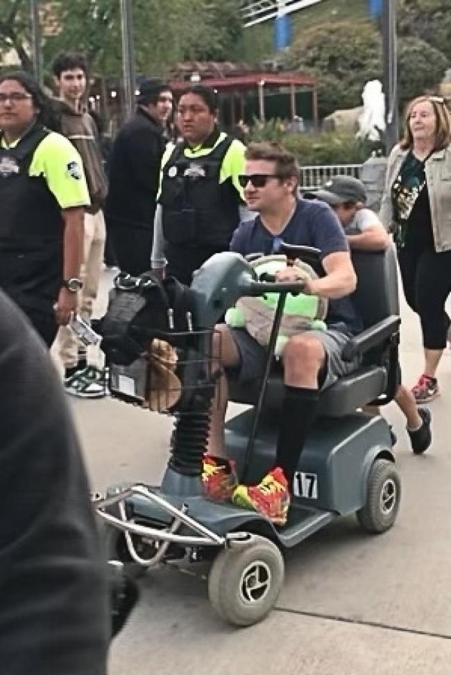 Jeremy Renner en un scooter electrico en Six Flags