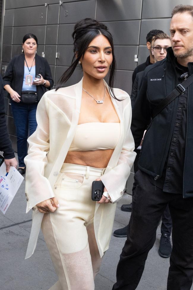 Kardashian mostro sus abdominales en el bandeau de color crema y uso un collar de placa personalizado