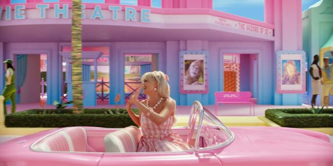 Barbie pasa frente a una sala de cine que proyecta exclusivamente la pelicula musical