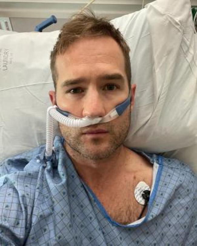 Morgan Chesky corresponsal de NBC News acostado en una cama de hospital con un tubo de respiracion