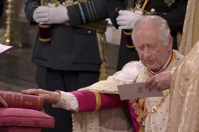 El monarca echó un vistazo a su túnica de coronación carmesí y su camisa blanca mientras juraba sobre la Biblia.