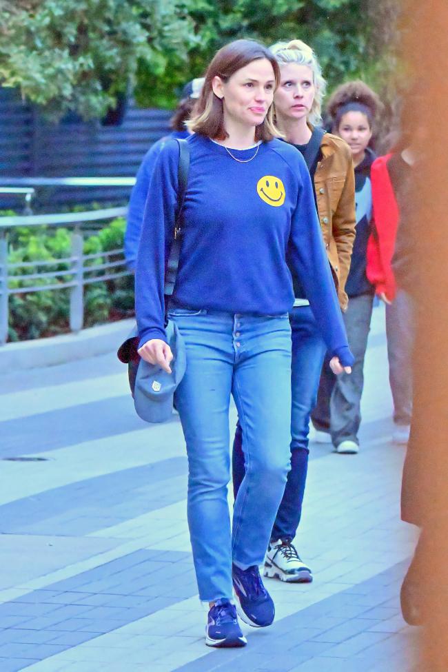 La actriz de “Elektra” vestía una camiseta azul de manga larga con una carita sonriente amarilla en el frente, jeans y tenis.
