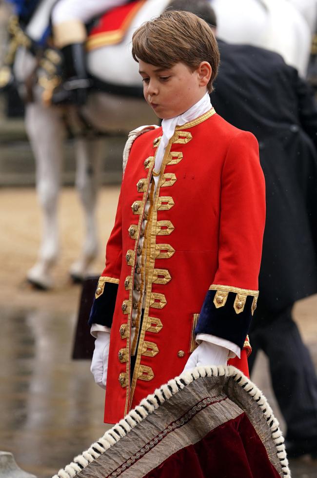 El príncipe George ayudó a llevar la túnica del rey Carlos.