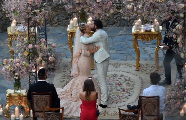 La pareja dijo sus votos bajo un arco adornado con aliento de bebé y rosas de color pastel.