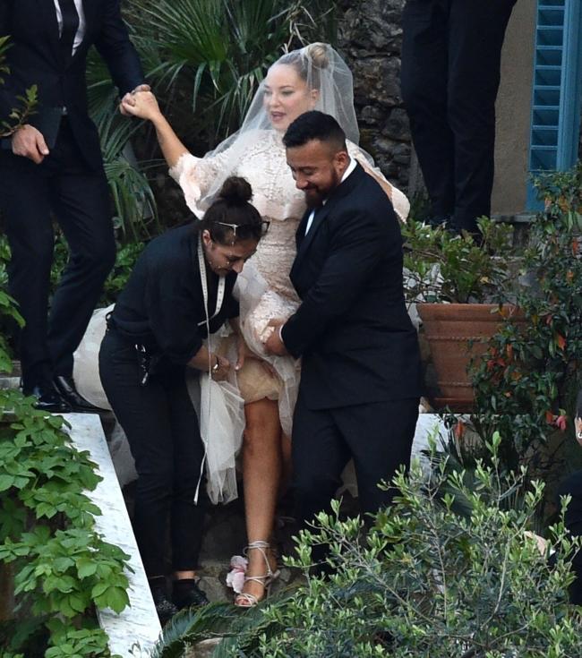 El personal tuvo que ayudar a Sia, que vestía un vestido de encaje estilo sirena, a bajar las escaleras.