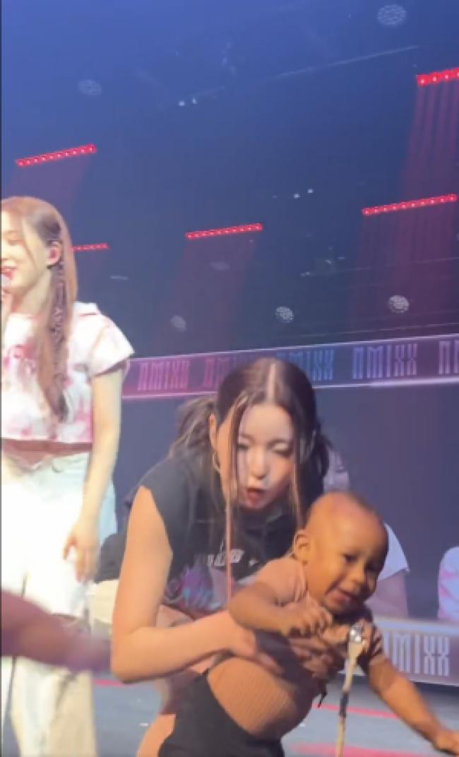 Kyujin sosteniendo a un bebe en el escenario