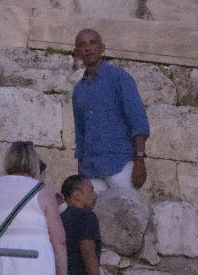 Barack estaba relajado con una camisa azul y pantalones blancos.